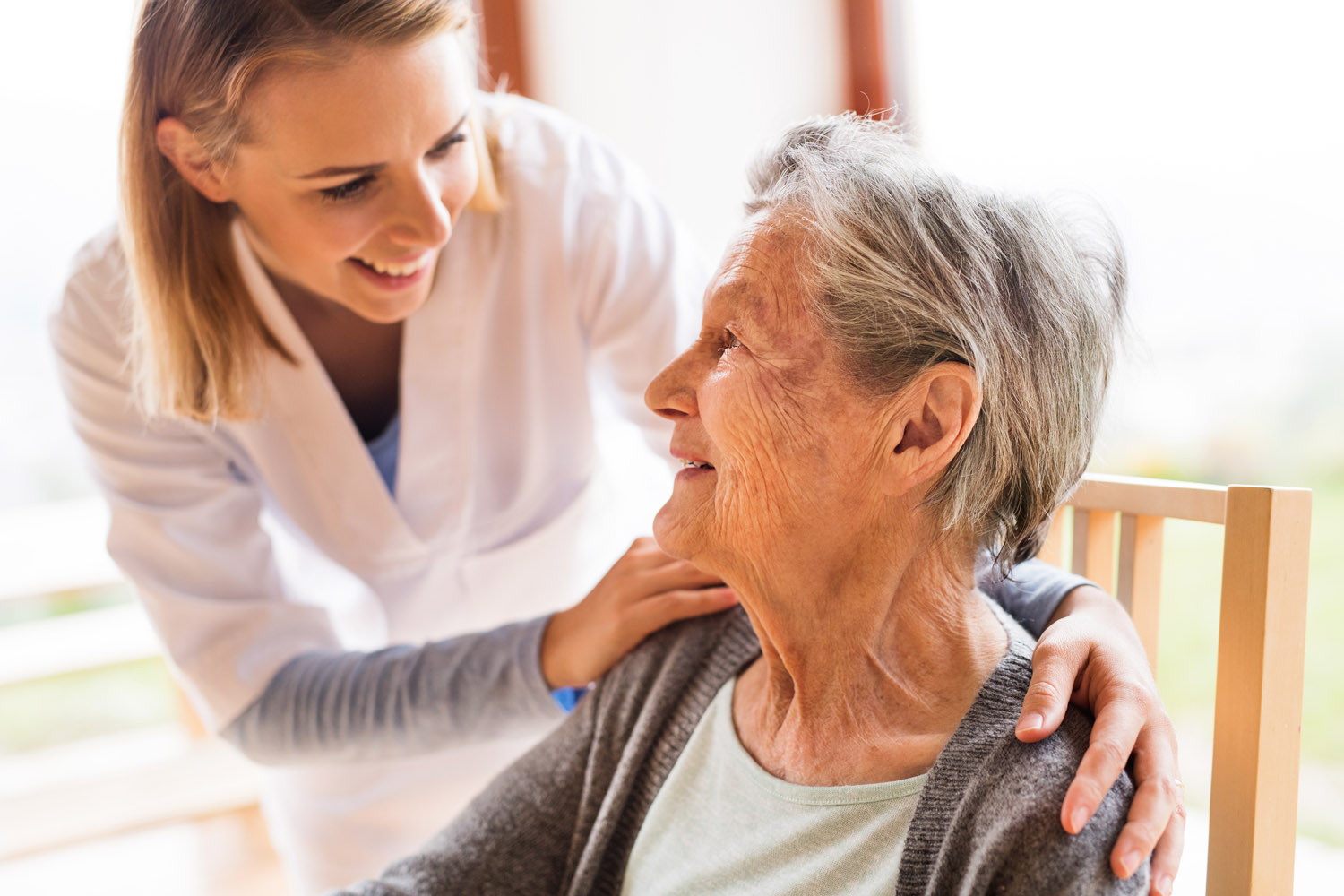 Health visitor and a senior woman during home visit. Health visitor and a senior woman during home visit. A nurse talking to an elderly woman.