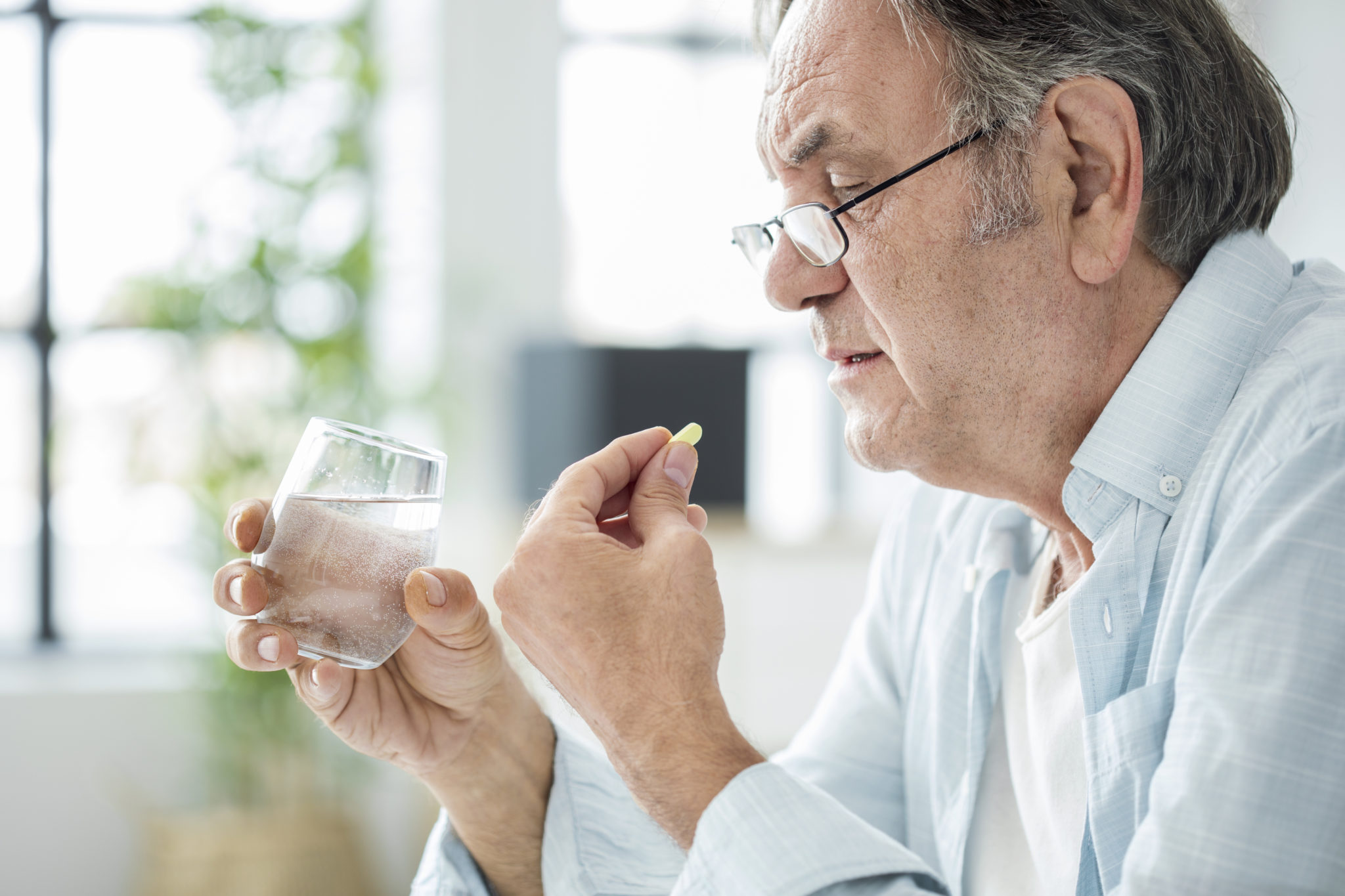 Old man taking a pill Old man taking a pill