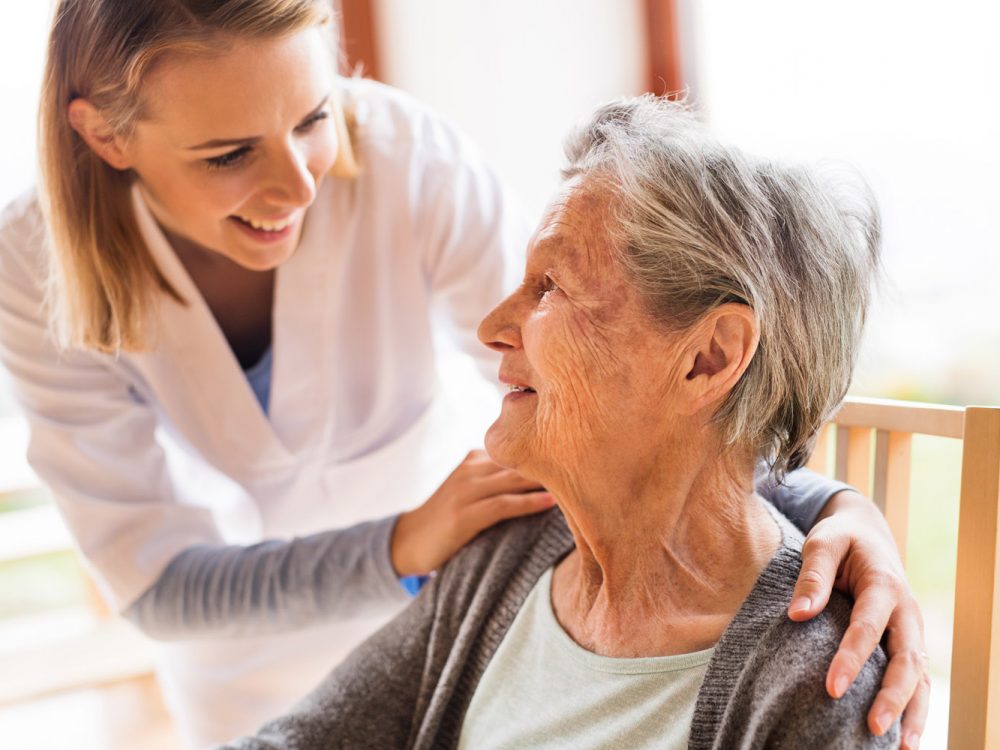 Health visitor and a senior woman during home visit. Health visitor and a senior woman during home visit. A nurse talking to an elderly woman.