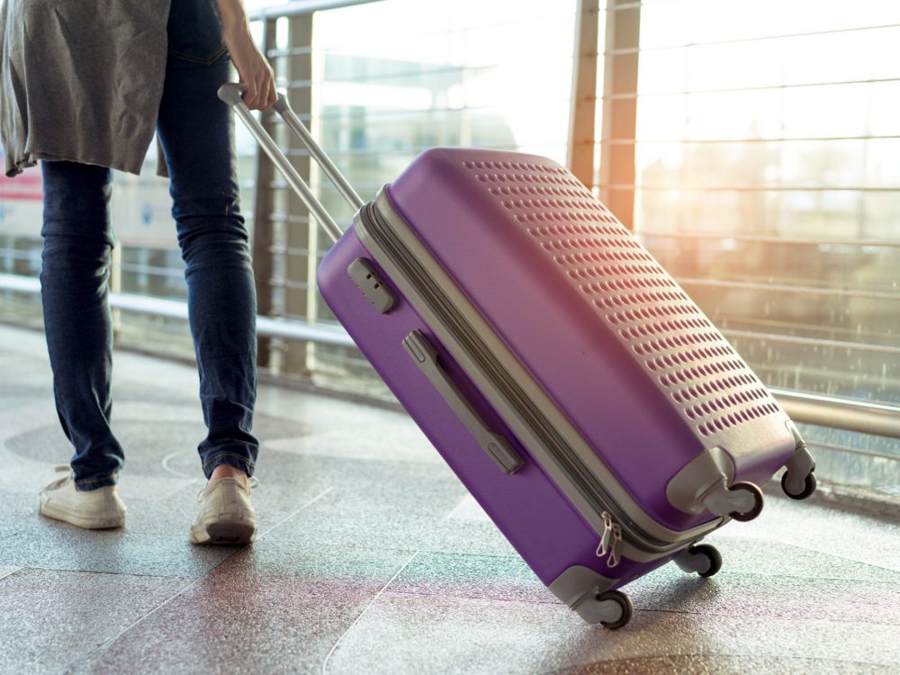 Young girl traveler walking with carrying hold suitcase luggage and passenger for tour travel booking ticket flight in airport international vacation time in holiday rest and relaxation. Young girl traveler walking with carrying hold suitcase luggage and passenger for tour travel booking ticket flight in airport international vacation time in holiday rest and relaxation.