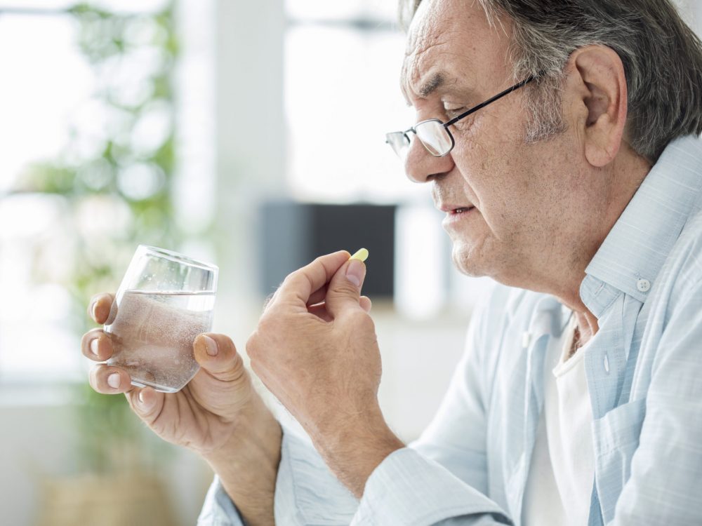 Old man taking a pill Old man taking a pill